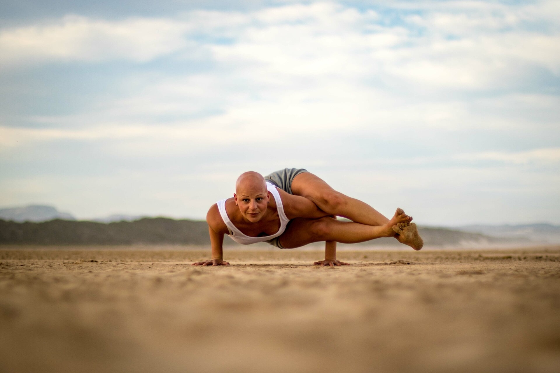 Yoga Astavakrasana on the beach, arm balance, in Jeffreys Bay, South Africa